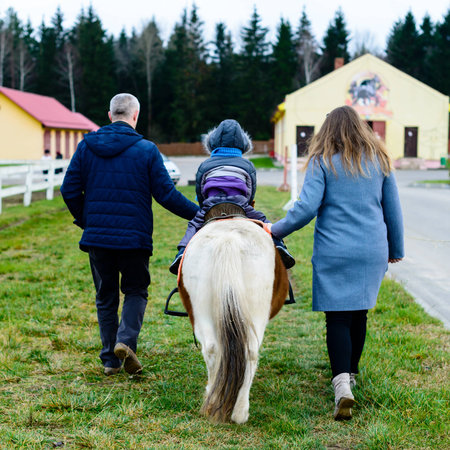 Child with parents taking a horseback rideの写真素材