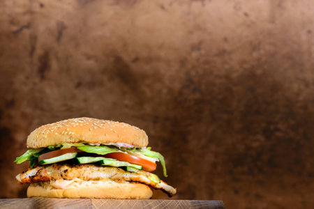 Delicious tasty burger with beef, tomatoes, salad and sauce on bの写真素材