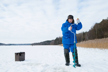 Firsheman catching fish on lake at winter cold dayの写真素材