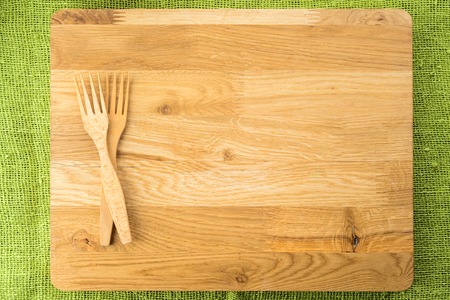 Wooden board with knives on green background with copyspace forの写真素材