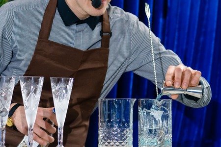 Unidentified barman adding liquid in a glass at the bar counterの写真素材