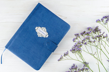 Blue leather notebook for men on white wooden background. Top view