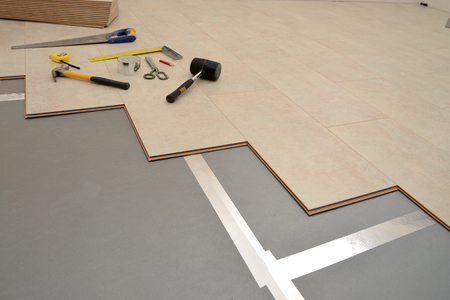 Installing wood parquet board during flooring workの写真素材