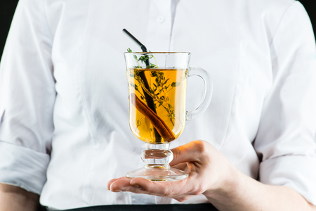 The unidentified waiter brings a hot Amaro cocktail with apple juice and cinnamonの写真素材