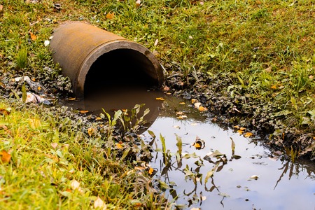Culvert pipe hole system draining sewage water with little puddlの写真素材