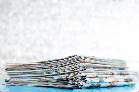 selective focus on stack of newspapers on wooden backgroundの写真素材