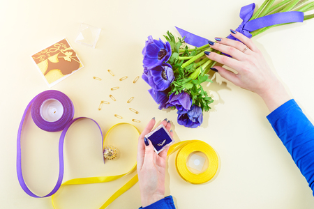 Concept of preparation woman for the holiday or wedding. Blue flowers, card, ring, yellow and blue ribbon on light background. Top view, flat layの写真素材