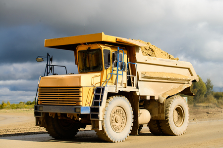 Extraction of minerals. Big yellow mining truck transporting materialsの写真素材