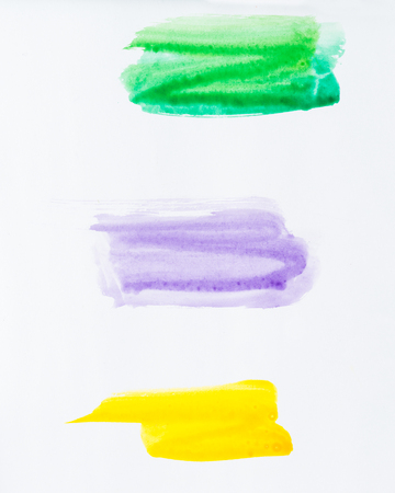 Set of watercolor brush strokes of green, purple and yellow paint on white background. Watercolor abstract textureの写真素材