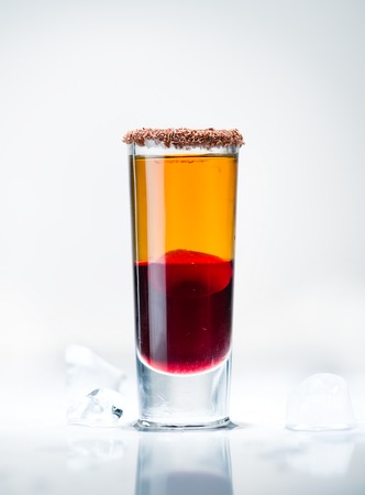 alcohol cocktail shot on a light background with reflectionの写真素材