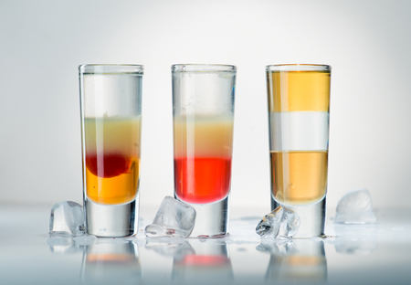 alcohol cocktail shot on a light background with reflectionの写真素材