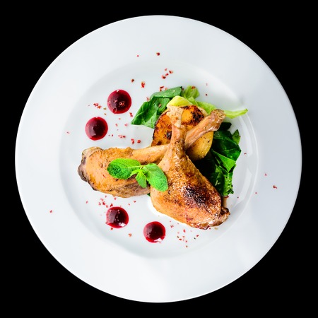 Juicy delicious cooked duck legs served with herbs and sauceの写真素材