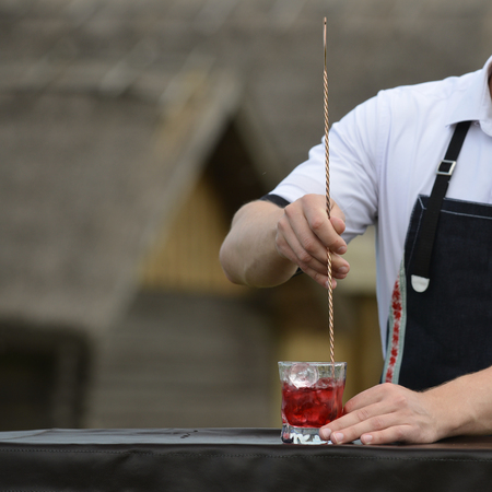 bartender workplace. bartender on the street catering bar preparing a coctail in a glass, selective focus, copyspace for text. Concept of preparation, service, vacation and relaxの写真素材