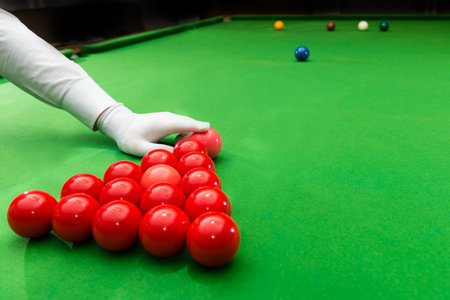 Snooker referee arranging pink ball at the beginning of a game