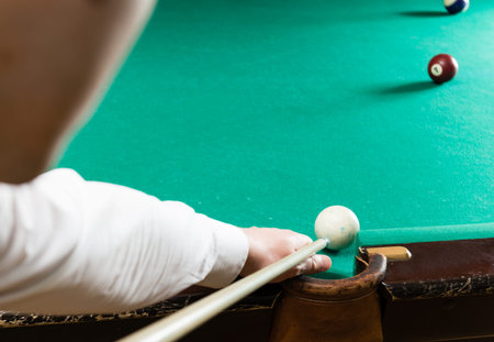 Billiards pool game, athlete with cue close-up, selective focus