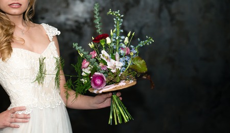 modern bridal bouquet in hands of bride with copy space on a dark backgroundの写真素材
