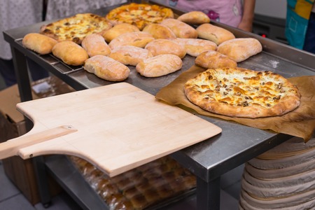 hot cooked Italian pizza with cheese, mushrooms and tomato sauce on a table. Cooking concept, cooking time, selective focusの写真素材