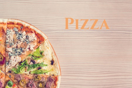 Mock up with copy space for text. Italian pizza compound from slices of different kind of pizzas on a wooden background . Top view, close-up, flat lay, toned imageの写真素材