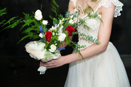 wedding bouquet in hands of the bride close-up on a dark background. Trendy and modern wedding...