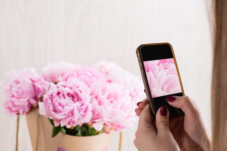 beautiful bouquet of pink peonies wrapped in paper for presentの写真素材