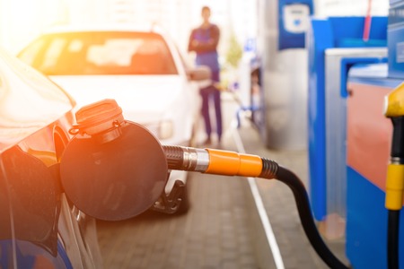 fuel nozzle to refill fuel in a car at sunset at petrol stationの写真素材