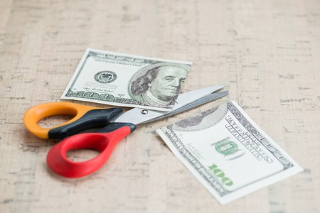 Cut in half 100 and scissors with copy spaceの写真素材