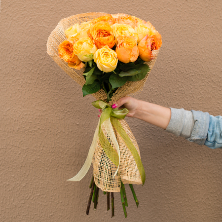 woman received a beautiful bouquet of yellow and orange roses, outdoors. Concept of holiday, Birthday, Mothers Day and Valentines Dayの写真素材
