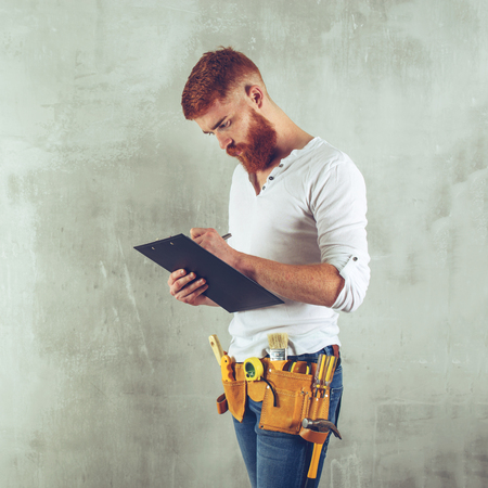 bearded brutal architect, an engineer writes in a tablet smile tonedの写真素材