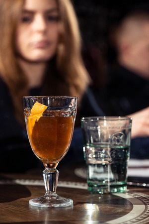 Cocktail bars, competition of bartenders, a jury of a girl and a man tasting a new alcoholic cocktail February 6th Bartender's Day Minsk, toned, Belarus, 2019のeditorial素材