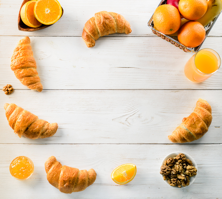 breakfast mockup oranges and croissants on a white wooden table, place for design copy space top view flat layの写真素材
