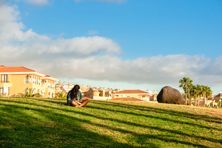 lonely woman lies on the beach and reads an e-book, Young woman reading a bookの写真素材