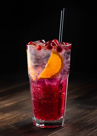 Refreshing cocktail with sparkling water with ice and cranberry, cranberry lemonade with ice, lingonberry cocktail in a tall glass with a strawの写真素材