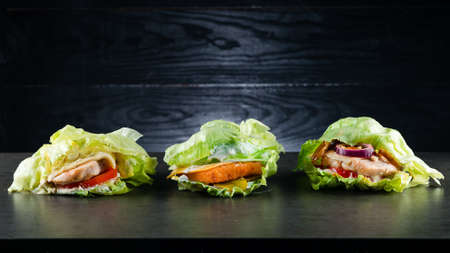 set collection three low-carb Burger, Protein lettuce wrapped burger lettuce wrap with toppings and copyspaceの写真素材