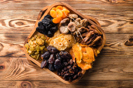 Mix of dried fruits symbols of judaic holiday Tu Bishvat. assorted dried fruits in wooden bowl, top view. organic food backgroundの写真素材