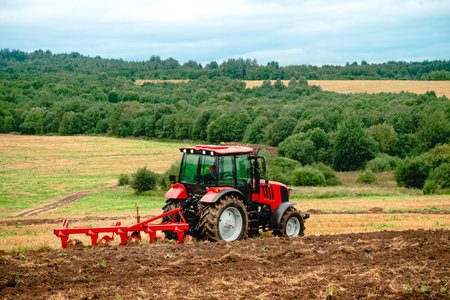 Tractor plowing the fields in the countryside, Agricultural tractor plowing the field