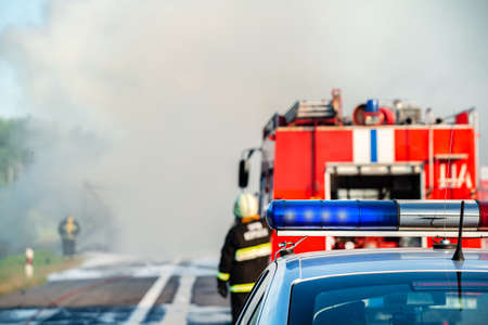 Police begin to shut down a road in preparation for Fire Fighters as a fire burns. police control a fire on the roadの写真素材