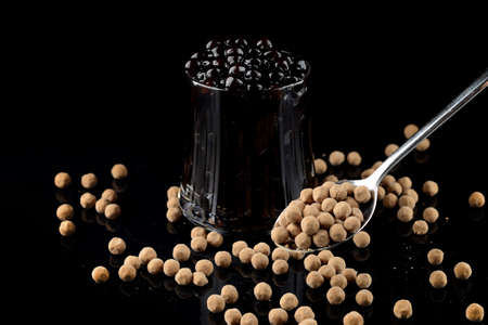Boiled Tapioca Pearls on black background. For Bubble tea concepts tapioca balls - a new trend in food and beverages. Raw Dry Organic Tapiocaの写真素材