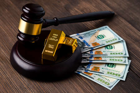 Judge's gavel with dollars and gold, judge's hammer and gold, concept of financial regulation in the price of goldの写真素材