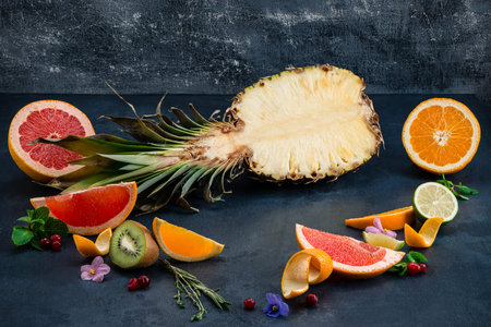 sliced pineapple and citrus fruit slices, sliced citrus fruits pineapple over dark background....