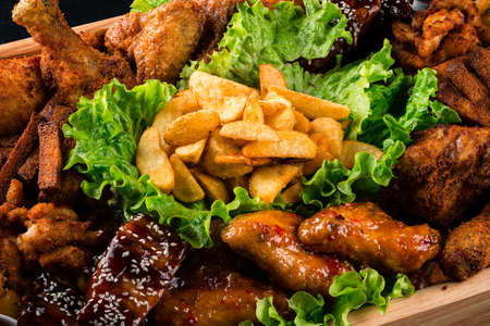 fat junk food close-up. fast food and unhealthy eating concept of fast food snacks on wooden tableの写真素材
