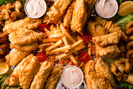 fat junk food close-up. fast food and unhealthy eating concept of fast food snacks on wooden tableの写真素材