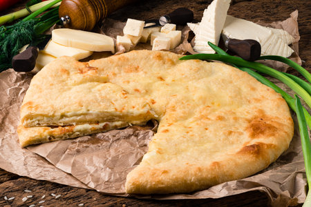 ossetian pie with cheese, Ossetian cuisine. Kadyndzdzhin onion and cheese pie on wooden surface.の写真素材