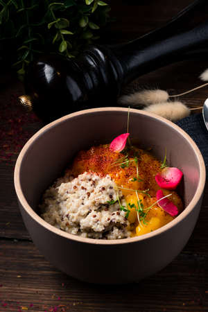 healthy vegan breakfast of quinoa with mango jam. Quinoa porridge with coconut milk in bowl wooden rustic background. Healthy Lactose and Gluten Free Breakfast. Vegetable quinoa bowlの写真素材