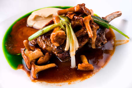 Roasted lamb chops with chanterelles and vegetables on decorated tableの写真素材