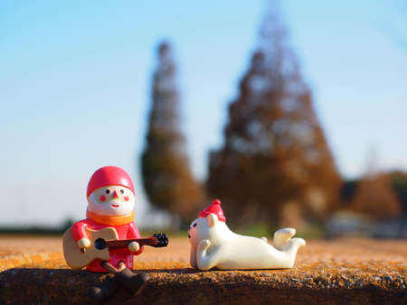 Santa Claus playing the guitar and polar bear listening the song figures in the forestの写真素材