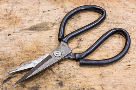 Old and dirty general purpose scissor on grunge wood tableの写真素材