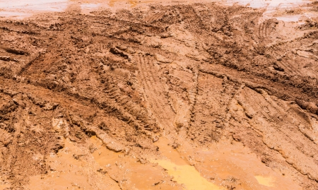 Wheel tracks on red color marshy road after rainingの写真素材