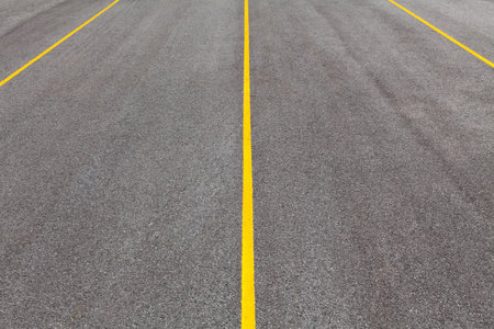 Black color asphalt road with yellow line