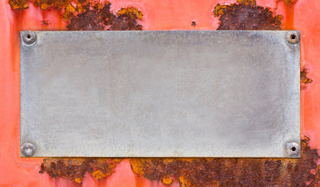 Close up grunge name plate on red color rusty steel sheet