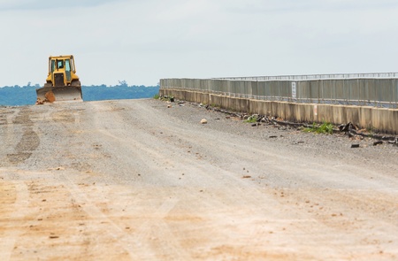 Yellow color backhoe working on dam crestの写真素材
